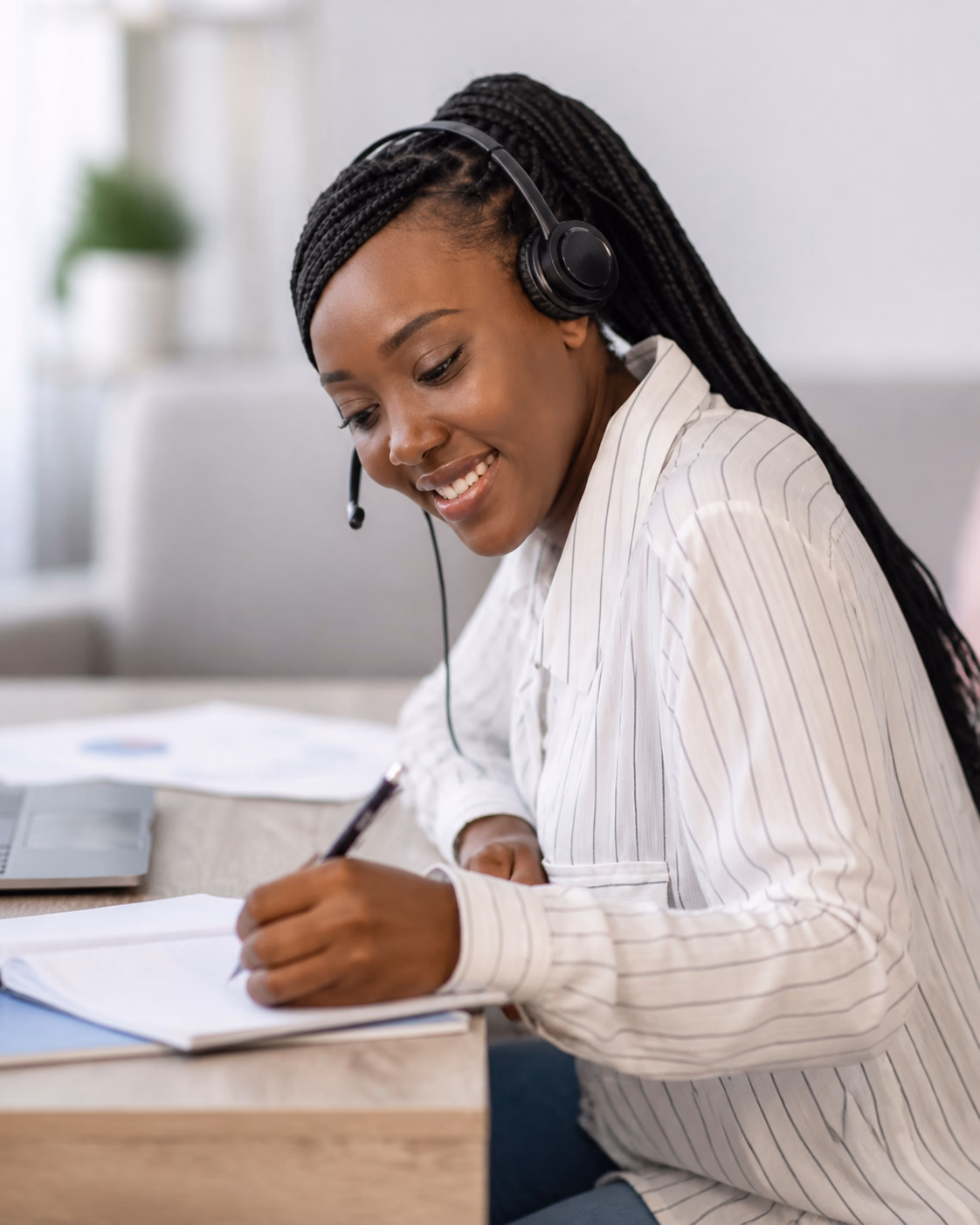 Apprenante suivant une formation en ligne et prenant des notes